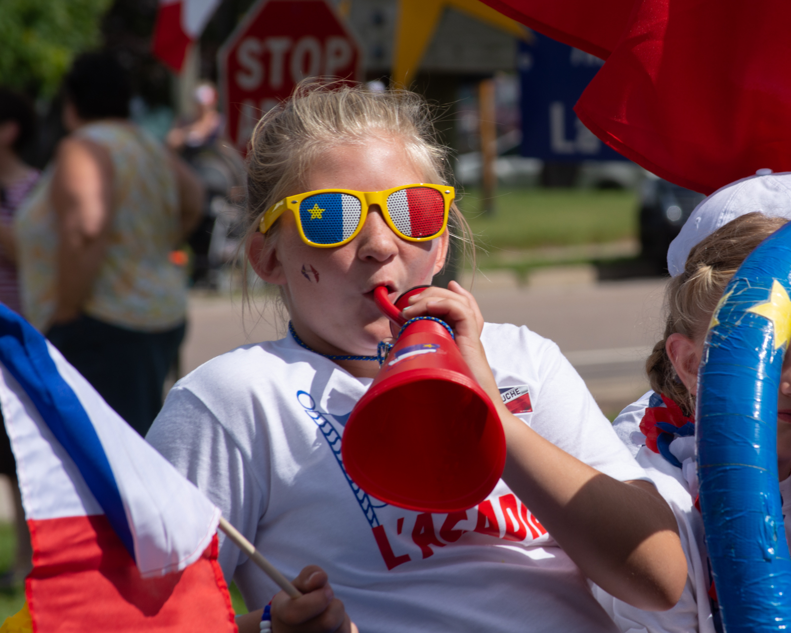 Child dressed with Acadian flag colour glasses