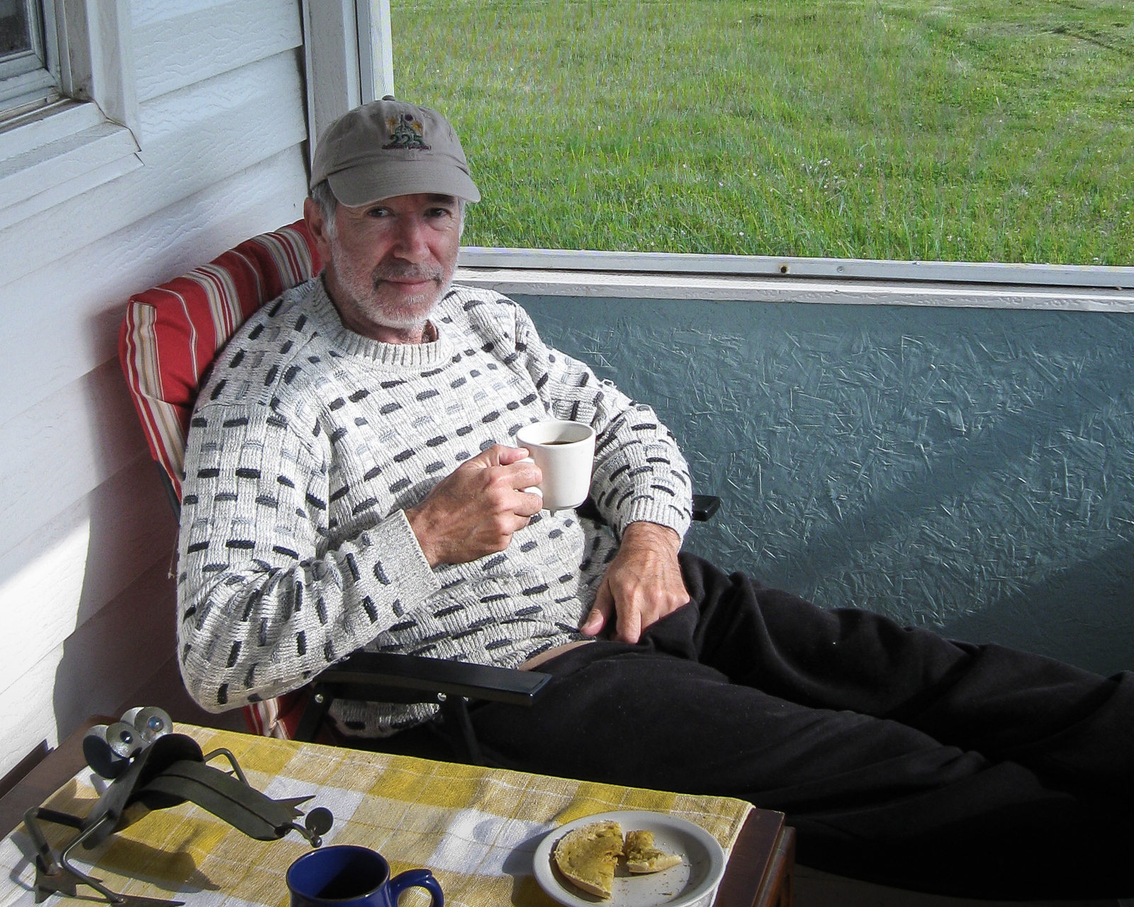 man drinking coffee on a porch